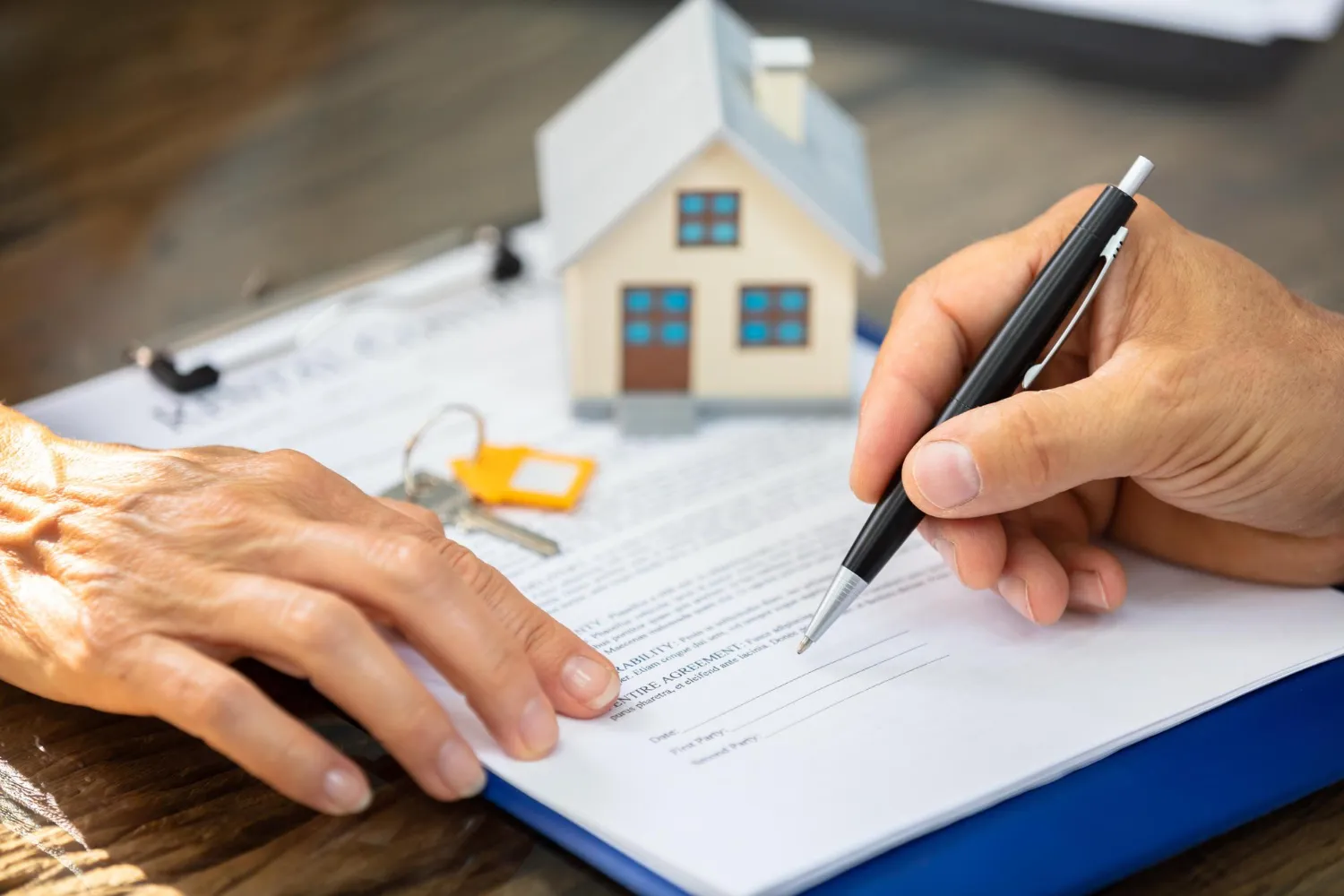 Assinatura de contrato imobiliário com chaves e casa, sobre atraso na entrega da obra direitos do comprador.