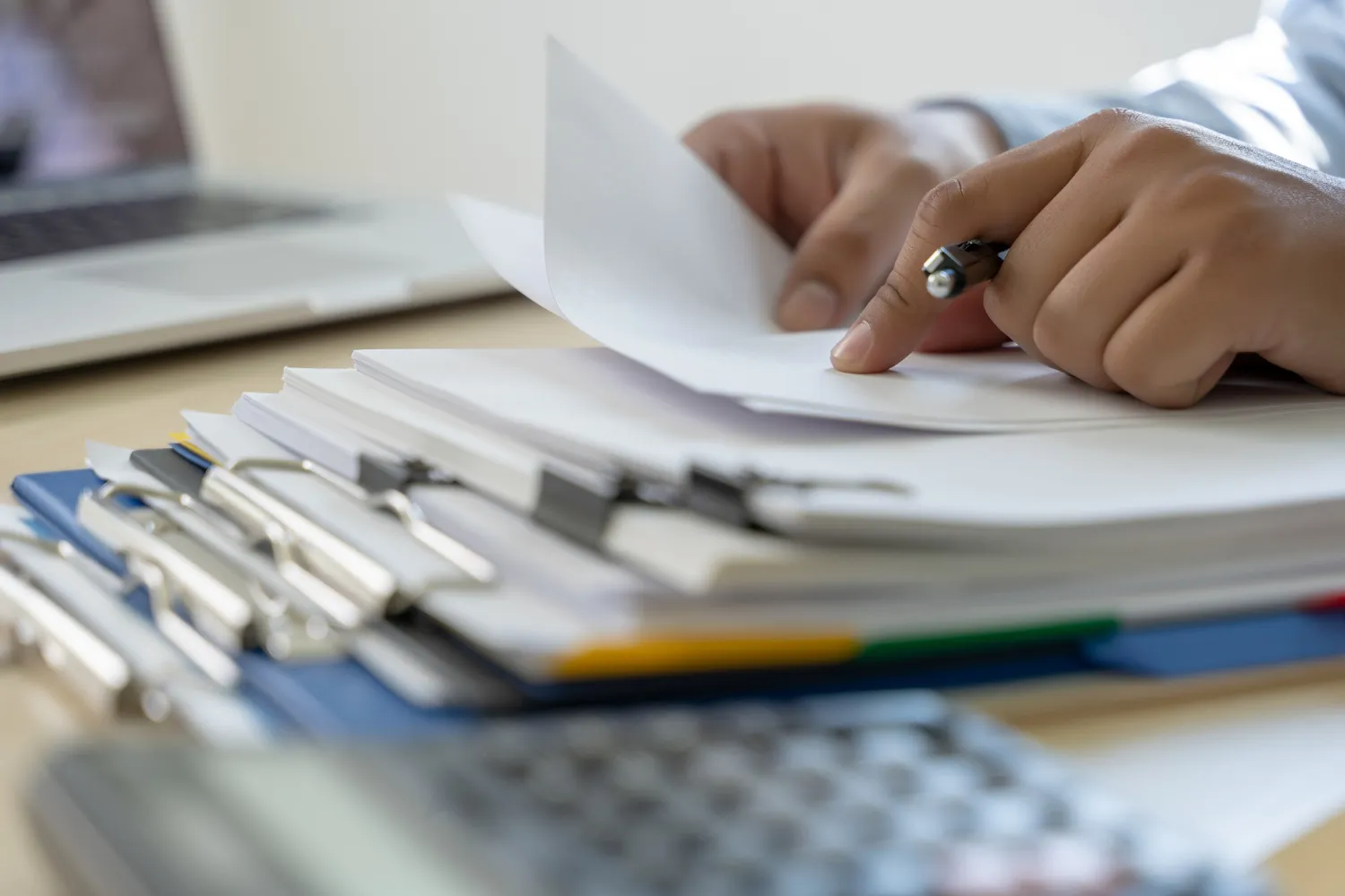 Mãos folheando documentos, buscando informações sobre CNH cassada o que fazer.