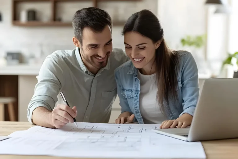 Casal analisa planta, preocupado pois comprou imóvel na planta e não entregaram.