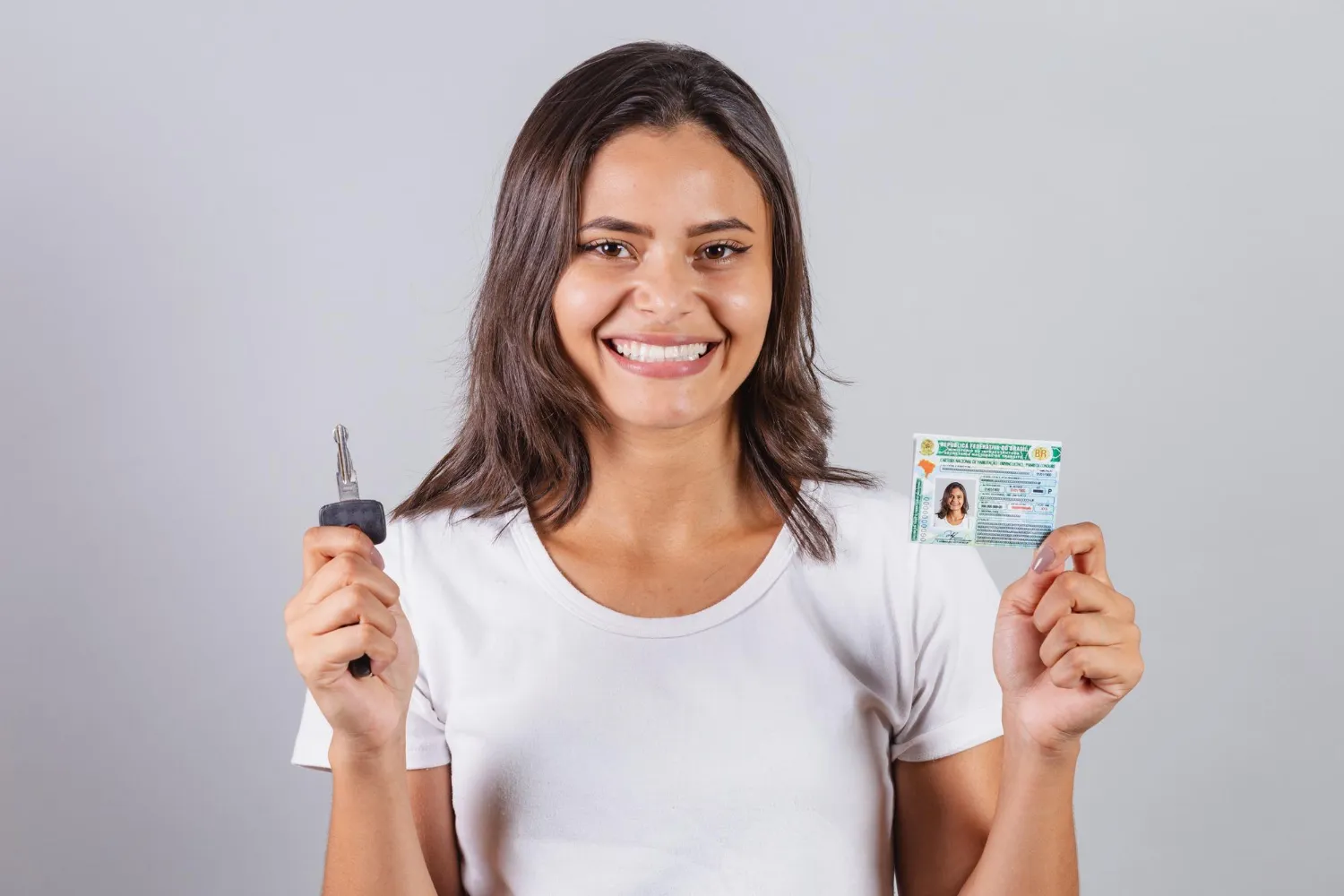 Mulher sorri segurando chave e CNH, dicas para evitar suspensão.